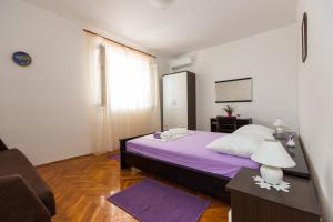 a bedroom with a purple bed and a chair at Apartments with a parking space Brsecine, Dubrovnik - 9098 in Brsečine