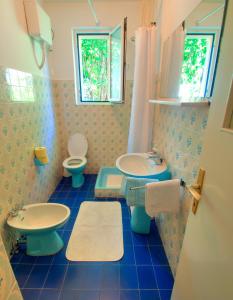 a blue tiled bathroom with two toilets and a sink at Apartments with a parking space Brsecine, Dubrovnik - 9098 in Brsečine