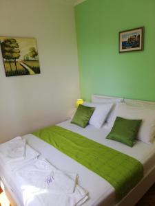 a bedroom with two beds with green and white pillows at Apartments with a parking space Vrbica, Dubrovnik - 9008 in Dubrovnik