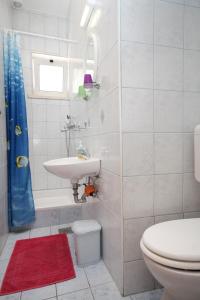 a white bathroom with a sink and a toilet at Apartments with a parking space Vrbica, Dubrovnik - 9008 in Dubrovnik