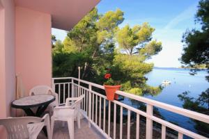 Un balcón con mesa y sillas y vista al agua. en Apartments by the sea Brna, Korcula - 9159, en Smokvica