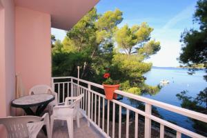 einen Balkon mit einem Tisch und Stühlen sowie Blick auf das Wasser in der Unterkunft Apartments by the sea Brna, Korcula - 9159 in Smokvica