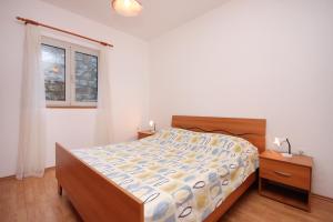 un dormitorio con una cama y una ventana en Apartments by the sea Brna, Korcula - 9159, en Smokvica