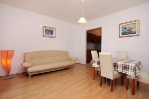 una sala de estar con un sofá y una mesa en Apartments by the sea Brna, Korcula - 9159, en Smokvica