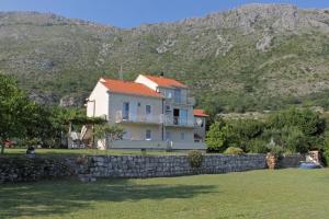ムリニにあるApartments for families with children Mlini, Dubrovnik - 8970の山を背景にした石垣の裏の家