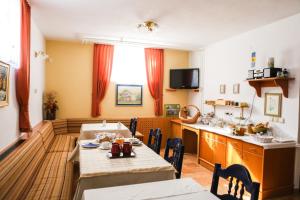 a dining room with two tables and a kitchen at Vila Romana in Kranjska Gora