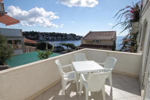 a table and chairs on a balcony with a view of the water at Seaside apartments with a swimming pool Zavalatica, Korcula - 9151 in Zavalatica