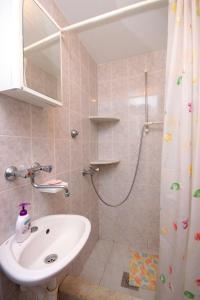 een badkamer met een wastafel en een douche bij Apartment Prigradica 9141b in Blato