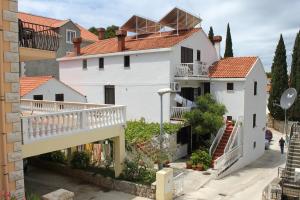 a white house with a balcony and a staircase at Apartments with a parking space Cavtat, Dubrovnik - 8993 in Mlini