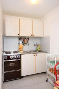 een keuken met witte kasten en een fornuis met oven bij Apartment Prigradica 9141b in Blato