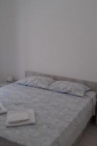 Una cama con dos toallas blancas encima. en Studio Molunat 8964b en Gruda