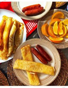 three plates of food with sausages and orange slices at Nikki's 2BR Home Ruiru, Thika Road in Nairobi