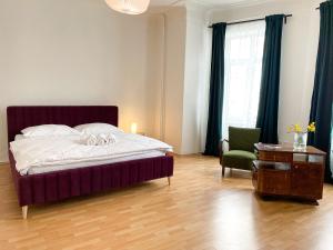 a bedroom with a bed and a chair and a table at Arch Apartment in Třebíč in Třebíč