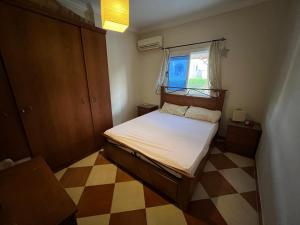 Morning Star Guesthouse في شرم الشيخ: غرفة نوم صغيرة بها سرير ونافذة