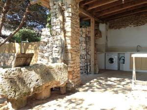 kamienny dom z ławką i pralką w obiekcie Villa Tina ai Piedi del Faro di Leuca w mieście Leuca