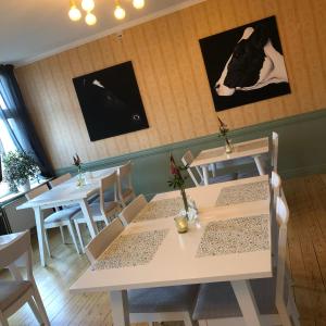 a restaurant with two tables and a cow on the wall at Ydre BnB in Österbymo