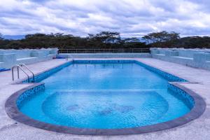 a large swimming pool with blue water at Alphas Homestay in Naivasha