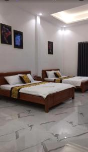 two beds are in a room with at Khách sạn KEN HOTEL DĨ AN in Dĩ An