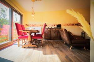 a dining room with a table and red chairs at La tanière Dinant in Dinant