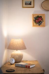 a lamp on a table with a book and an alarm clock at Andalusian Courtyard in Seville