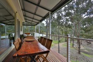 a wooden table on the porch of a house at Devinegetaway in Eildon