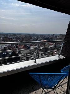 a blue chair sitting on a balcony with a view at Beachfront Studio in Blankenberg (Belgium) in Blankenberge