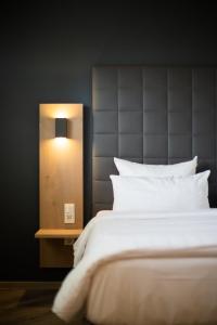 ein Schlafzimmer mit einem Bett und einer Lampe daneben in der Unterkunft Hotel Circle Inn in Ramstein-Miesenbach