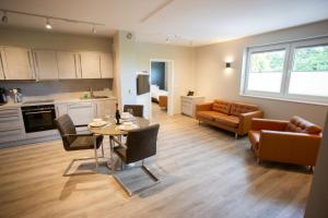 eine Küche und ein Wohnzimmer mit einem Tisch und einem Sofa in der Unterkunft Hotel Circle Inn in Ramstein-Miesenbach
