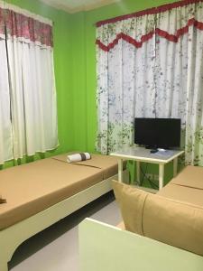 Habitación con 2 camas y escritorio con ordenador. en Twin AP Homes, en Boracay