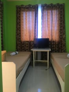 a room with two beds and a laptop on a table at Twin AP Homes in Boracay +18 photos