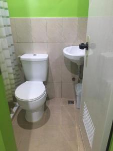 a bathroom with a white toilet and a sink at Twin AP Homes in Boracay