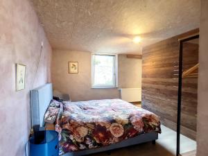 een slaapkamer met een bed en een houten muur bij L'Eglantine in Rochefort
