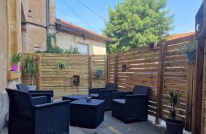 a patio with chairs and tables and a fence at appartement cosy en centre ville avec terrasse in Villefranche-sur-Saône