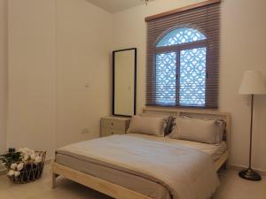 a bedroom with a bed with a mirror and a window at Cozy 1BR Apartment close to Dragon Market and Global Village in Dubai