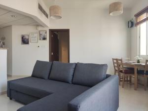 a blue couch in a living room with a table at Cozy 1BR Apartment close to Dragon Market and Global Village in Dubai