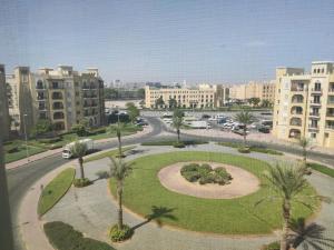 a park in the middle of a city with buildings at Cozy 1BR Apartment close to Dragon Market and Global Village in Dubai