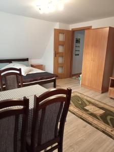 sypialnia z 2 łóżkami, stołem i krzesłami w obiekcie Na wzgórzu w mieście Krośnica