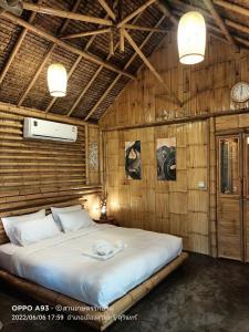 - une chambre avec un lit dans une pièce en bois dans l'établissement สวนเกษตรรักษ์ไผ่ Bamboo Conservation Farm, à Surin