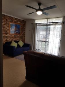 キングズコートにあるLodge on the Bay- now Backpacker's Price in Esplanade & Buller St Kingscote-Pay on arrivalのソファと天井ファンのあるリビングルーム
