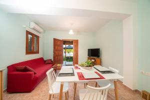 un soggiorno con divano rosso e tavolo di Afroditi Holiday Home - Blue Apartment a Svoronáta