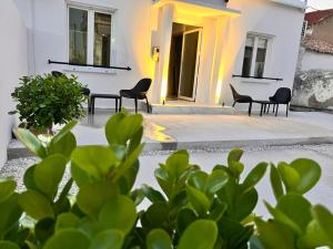 patio z krzesłami i roślinami przed budynkiem w obiekcie Perla Coco Jacuzzi Suites w Chanii