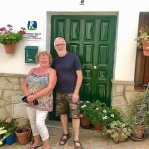 un homme et une femme debout devant une porte verte dans l'établissement Casa de las Flores - a picture perfect location!, à El Gastor