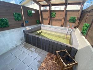 a hot tub in a building with a tennis court at ETAVIA Yufuinekimae in Yufuin