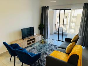 a living room with a couch and chairs and a television at Villa 86, Ballito in Ballito