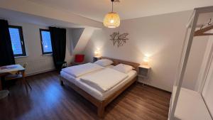 um quarto com uma cama, uma mesa e um candeeiro em Hotel Sonne em Wassertrüdingen