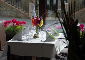 a white table with wine glasses and flowers on it at Hotel Richard Spa & Wellness in Mariánské Lázně