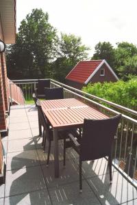 d'une table et de chaises en bois sur un balcon. dans l'établissement Heimathafen, à Langeoog