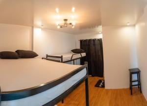 八打雁The Pod Mabini的有两张床、一张桌子和一张椅子的房间