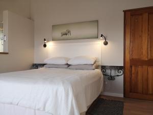 a bedroom with a large white bed with two pillows at St Francis Bay House On The Canal in St Francis Bay