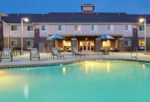- une piscine de nuit avec des tables et des chaises en face d'un hôtel dans l'établissement Holiday Inn Express Monticello, an IHG Hotel, à Monticello